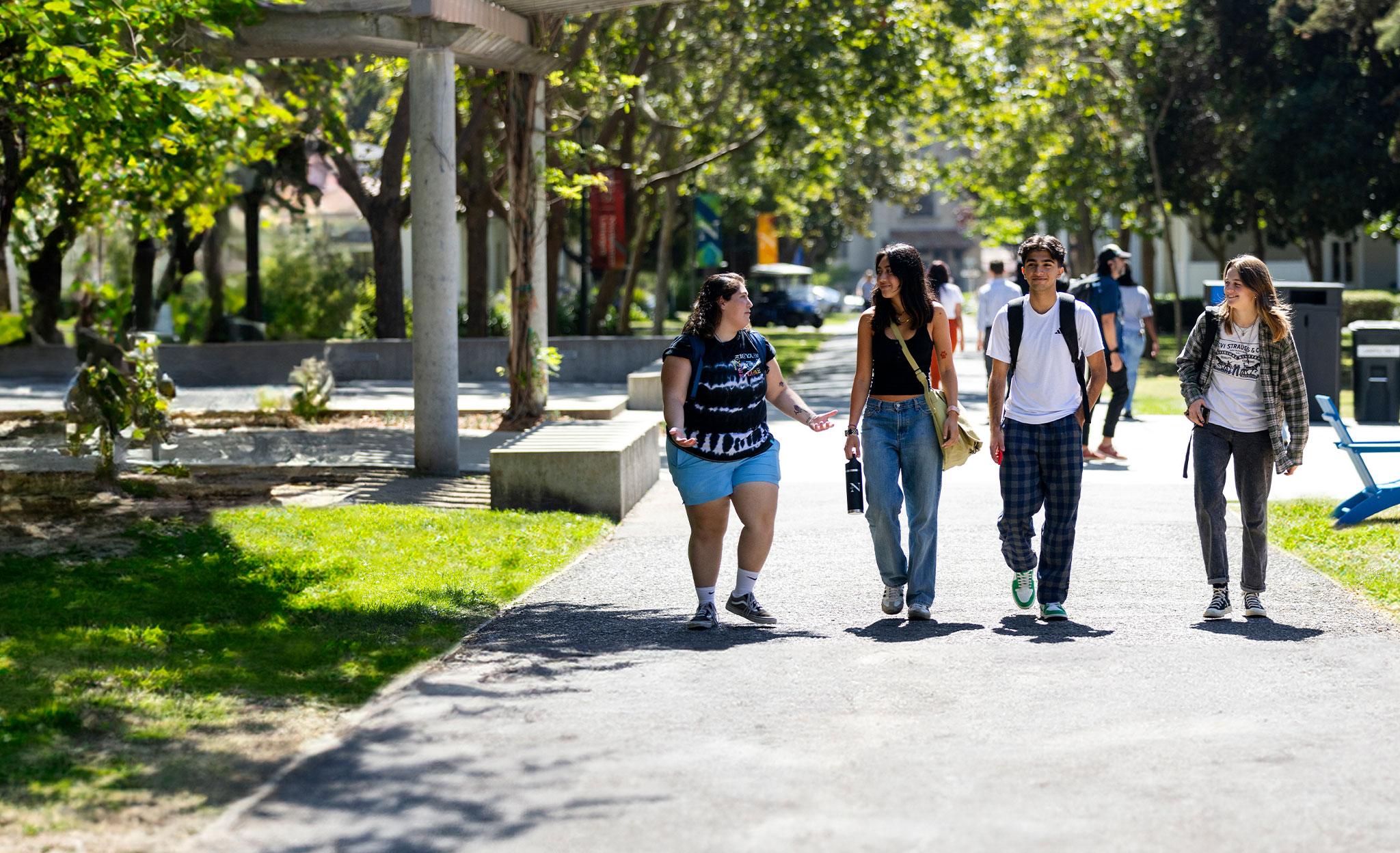 Group of students walk along path to Suzanne Adams Plaza.