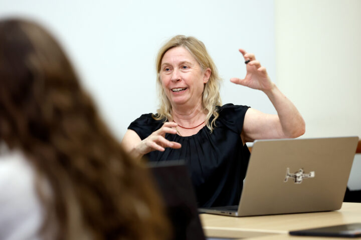 Juliana Spahr, English professor at Northeastern University's Oakland campus, gestures with hands as she speaks to class.