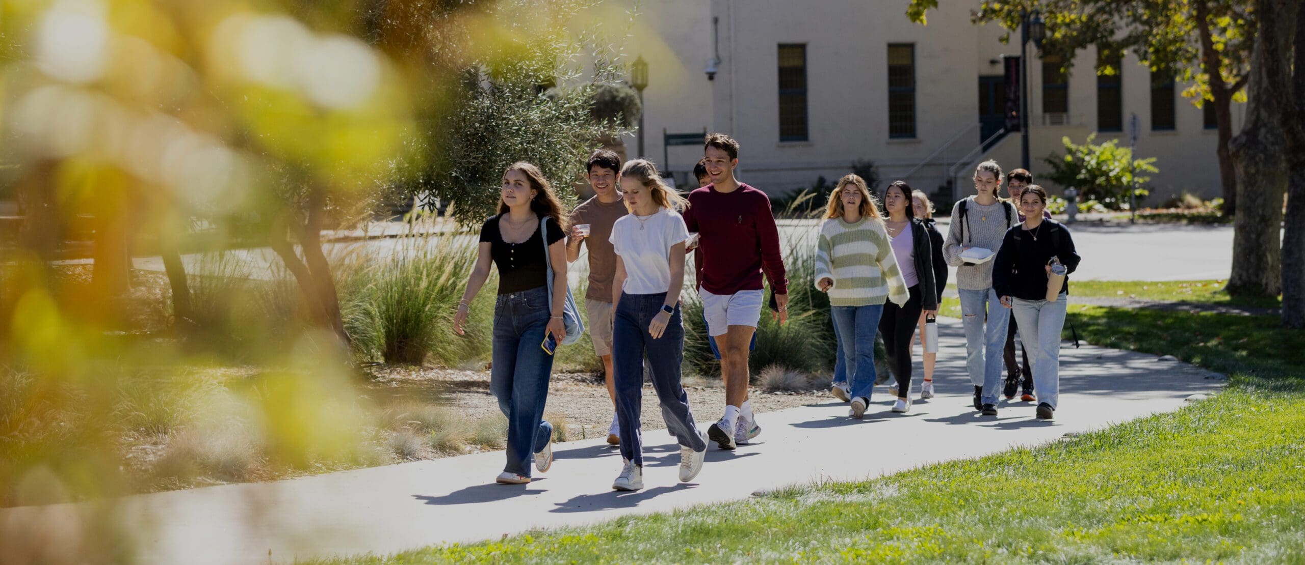 Students walk up path towards the Lorry I. Lokey School of Business and Public Policy building on the Northeastern University Oakland campus