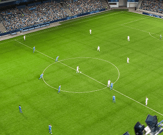 Soccer players in blue and white uniforms are on the field, preparing for kickoff in a stadium with a large crowd of spectators in the stands.