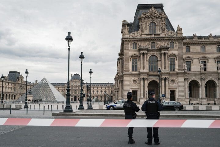 French police officers stand in front of the Louvre Museum after robbers broke in and fled with pieces included in the French Crown jewels.