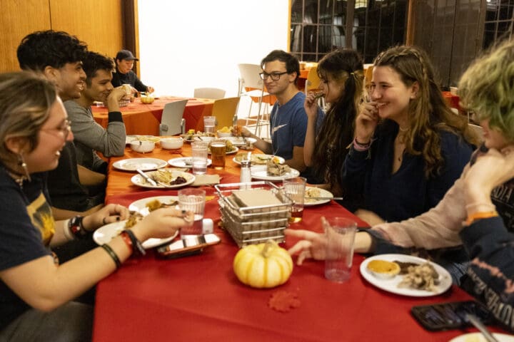 Students gather around table for a Friendsgiving dinner
