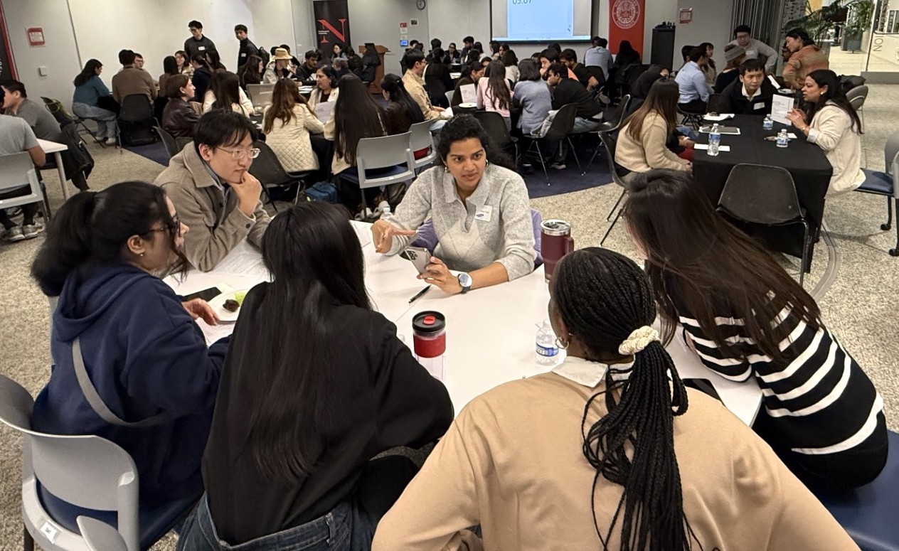 A  group of graduate students seated at a table during a speed mentoring event.